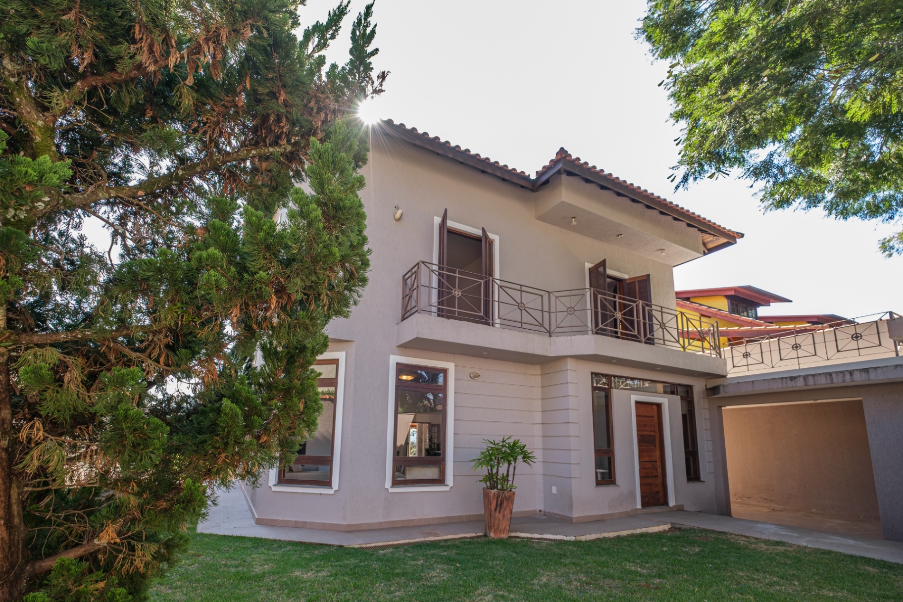 Fachada frontal da casa com jardim e garagem