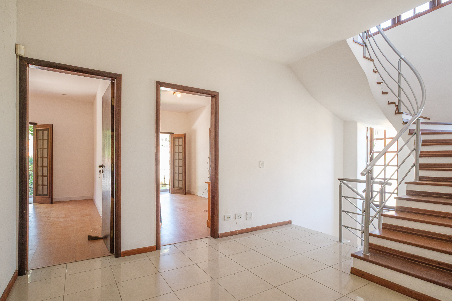 Hall com escada caracol em aço e madeira
